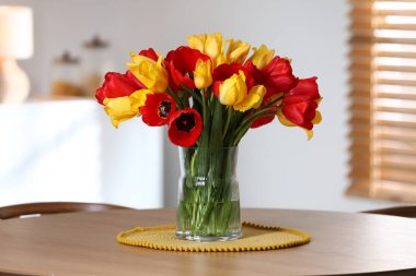 İçerideki ahşap masada vazodaki güzel laleler.