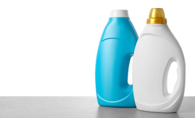 Beyaz arkaplana karşı gri masada yumuşatıcı şişeler