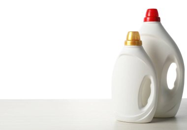 Beyaz arka plana karşı ahşap masada yumuşatıcı şişeler.