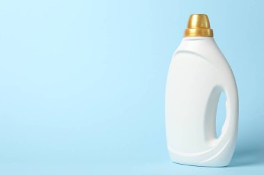 Açık mavi arkaplanda bir şişe yumuşatıcı, metin için boşluk