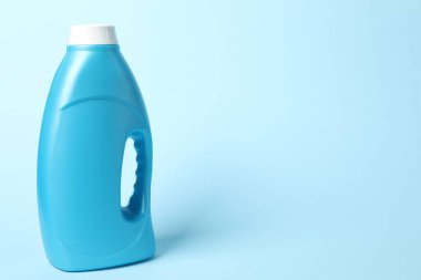 Açık mavi arkaplanda bir şişe yumuşatıcı, metin için boşluk