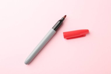 Açık pembe arkaplanda bir kırmızı işaret, üst görünümde.