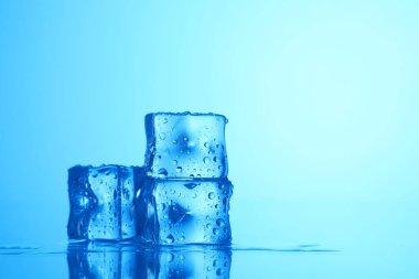 Açık mavi zemin üzerinde açık buz küpleri, yakın plan. Metin için boşluk