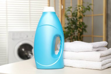 İçerideki masada yumuşatıcı ve havlu şişesi.