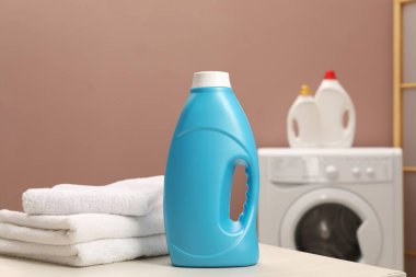 İçerideki masada yumuşatıcı ve havlu şişesi.