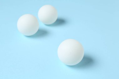 Açık mavi arkaplanda pinpon topları, yakın plan