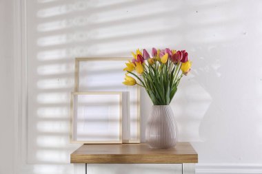 İçerideki ahşap masada güzel laleler ve çerçeveler.