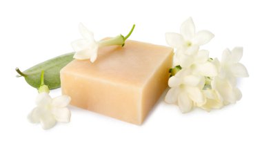 Bir kalıp sabun ve yasemin çiçekleri beyaz üzerine izole edilmiş.