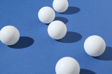 Mavi arkaplanda birçok ping pong topu, yakın plan