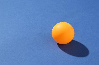 Mavi arka planda bir pinpon topu, yakın plan. Metin için boşluk