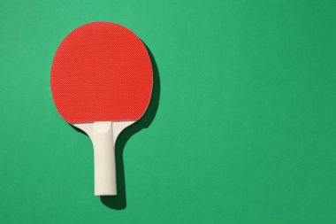 Yeşil arka planda bir pinpon raketi, üst manzara. Metin için boşluk