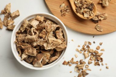 Beyaz masanın üzerinde kurumuş hindiba kökleri var.