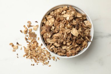 Beyaz masadaki kasede kurumuş hindiba kökleri var.