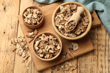 Kase içinde kuru hindiba kökleri ve ahşap masa üzerinde kepçe, üst görünüm