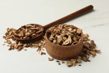 Kuru hindiba kökleri kasede ve kaşıklar beyaz masada.