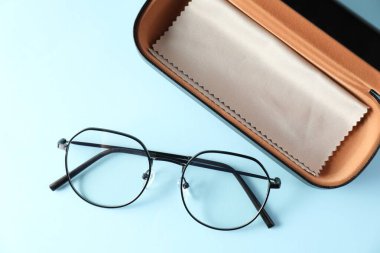 Şık gözlüklü çanta ve açık mavi arka planda temiz bez, düz yatıyordu