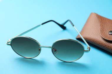 Açık mavi arka planda şık gözlüklü çanta, yakın plan