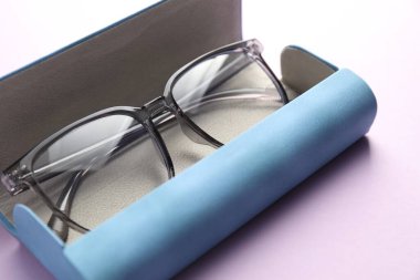 Mor arka planda şık gözlüklü çanta, yakın plan