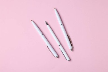 Pembe arka planda tükenmez kalemler, düz yatış