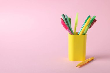 Tükenmez kalemler pembe arka planda, yakın plan. Metin için boşluk