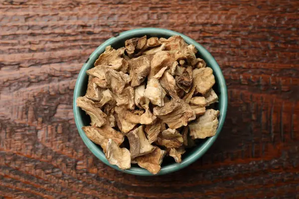 Kuru hindiba kökleri tabakta, ahşap masada, üst tarafta.