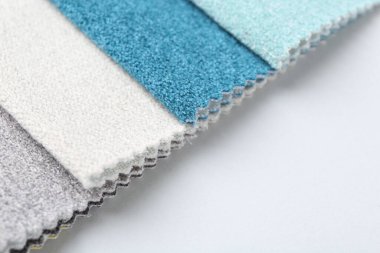 Beyaz arka planda farklı kumaş örnekleri, yakın plan. Metin için boşluk