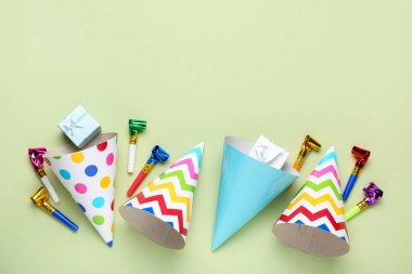 Düz kompozisyon ve açık yeşil arka planda parti şapkaları. Metin için boşluk