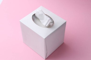 Pembe arka planda kağıt mendilli kutu, yakın plan.