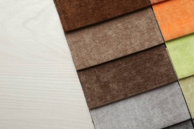 Açık ahşap masadaki farklı kumaşlardan örnekler, üst manzara. Metin için boşluk