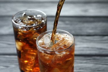 Gri ahşap masada ferahlatıcı kolayı cama boşalt.