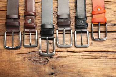 Tahta masanın üzerinde bir sürü farklı deri kemer vardı.