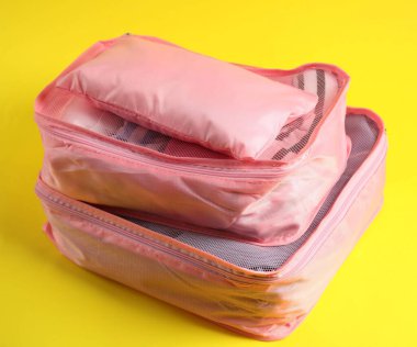 Sarı arka planda elbiseli küplerin paketlenmesi, yakın plan