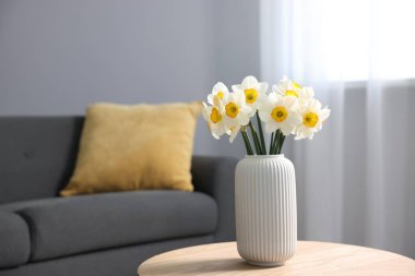 İçerideki ahşap masada vazodaki güzel nergisler, metin için yer.