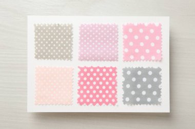 Hafif ahşap masa üzerinde benekli kumaş örnekleri, üst görünüm