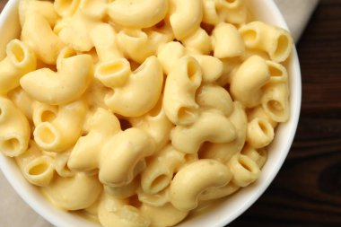 Ahşap masanın üstünde nefis bir makarna ve peynir.