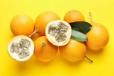 Olgun tutku meyveleri ve sarı arka planda yapraklar, düz uzanmış