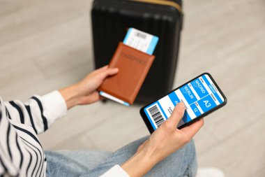 Otobüs ve pasaport için e-bileti olan cep telefonlu turistler, yakın plan.