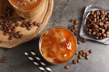 Lezzetli buzlu kahve ve fasulye gri masada, düz yerde.