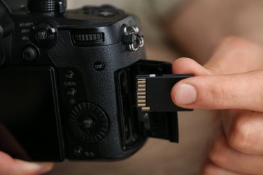 SD bellek kartını fotoğraf makinesine yerleştiren adam, kapat