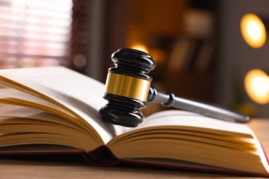 Yargıç tokmağı ve kitabı kapalı bir masa üzerinde, yakın plan.