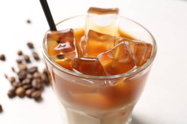 Lezzetli buzlu kahve ve fasulyeler beyaz masada, yakın plan.