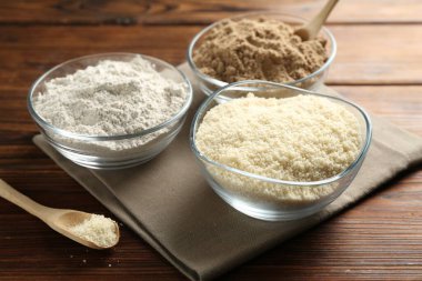 Tahta masadaki kaselerdeki farklı un türleri, yakın plan.