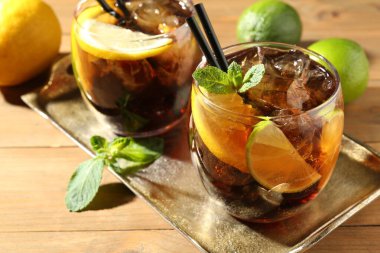 Küba libre kokteylini ahşap masada nane şekeri ile tazeliyorum.