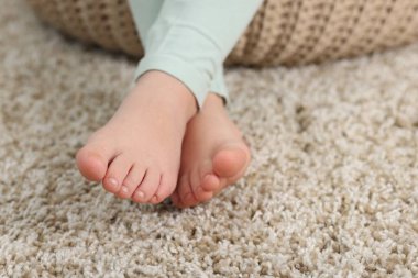 Evdeki yumuşak halıdaki kız, yakın plan.