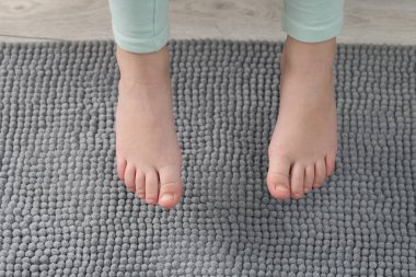 Evdeki yumuşak halının üstündeki kız, yakın plan.