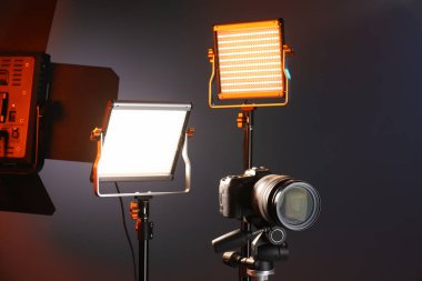 Renkli arka planda profesyonel ışıklandırma ekipmanı ve kamera