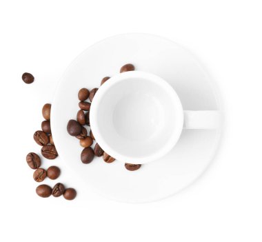 Aromatik kahve çekirdekleri, fincan ve çay tabağı beyaza izole edilmiş.