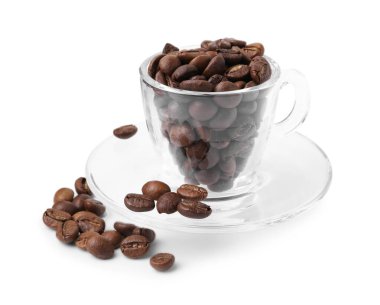 Aromatik kahve çekirdekleri ve çay tabağı beyaza izole edilmiş.