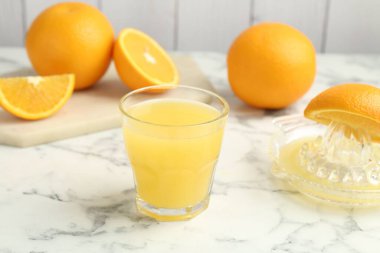 Taze portakal suyu, meyveler ve sıkma beyaz mermer masa, yakın plan.