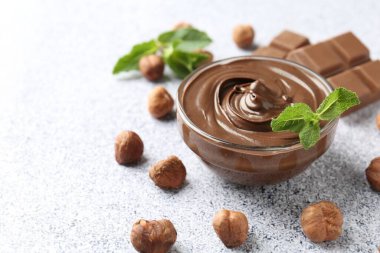 Lezzetli çikolata, naneli kase ve fındıklı gri desenli masa, yakın plan. Metin için boşluk